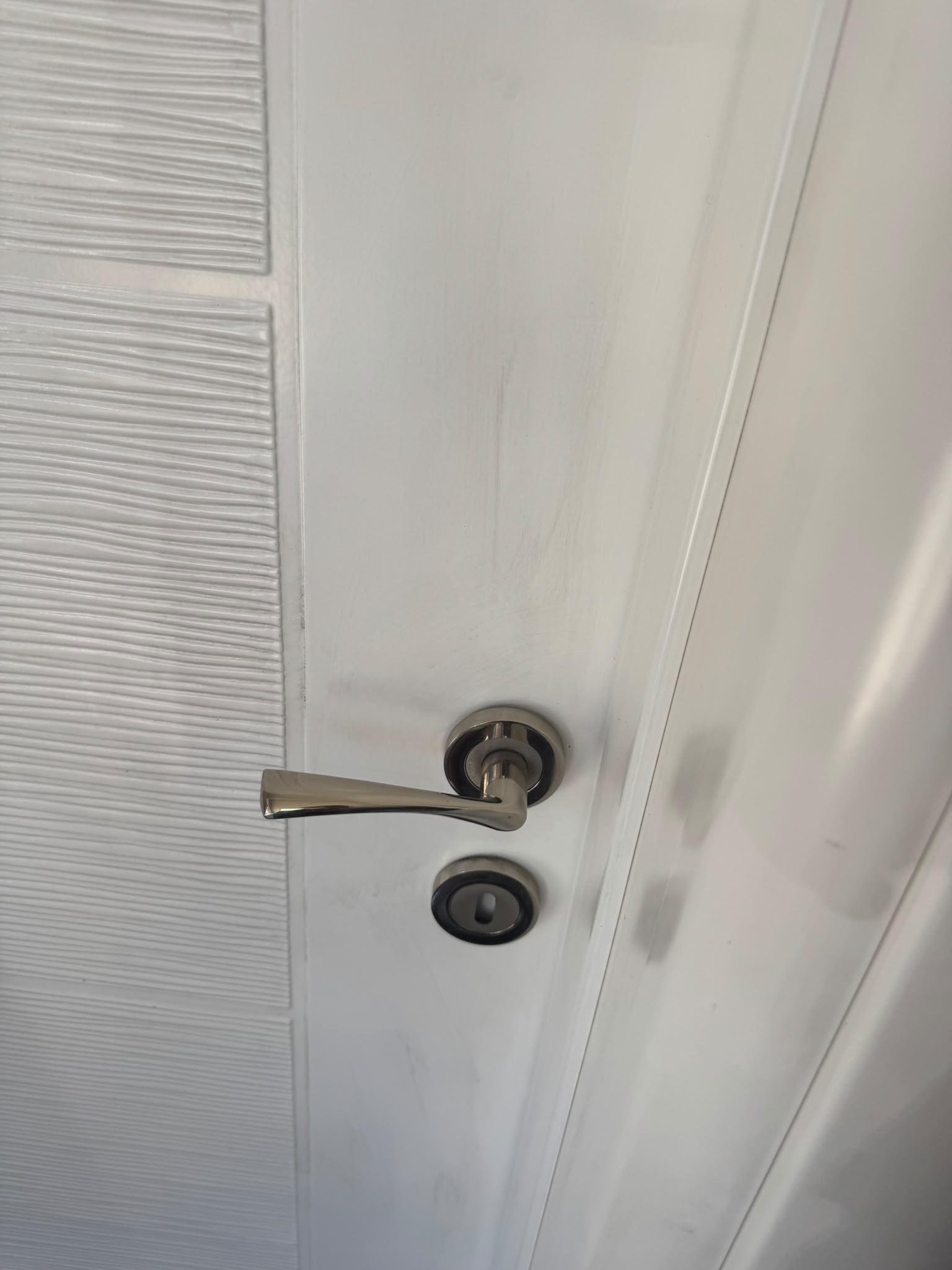 Detalj metalne kvake na belim vratima